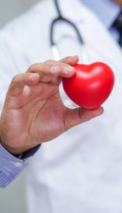 Doctor holding red heart in his hand in nursing hospital ward : healthy strong medical concept